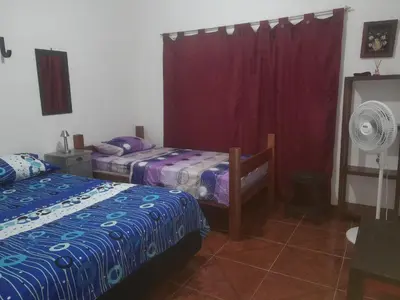 a bedroom with two beds and a fan at Casa del Rio Low cost in Honda