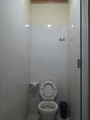 a white bathroom with a toilet with the lid up at Casa del Rio Low cost in Honda
