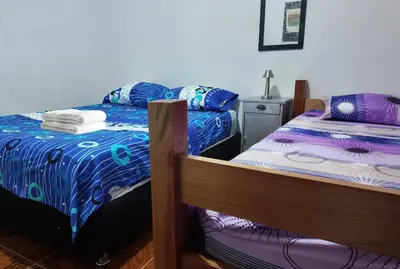a bedroom with two twin beds and a night stand at Casa del Rio Low cost in Honda