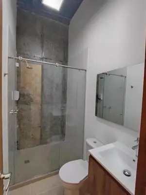 a bathroom with a shower and a toilet and a sink at Hostal The Nest By Ulivin in Manizales