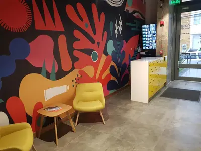 a room with a chair and a colorful wall at Hostal The Nest By Ulivin in Manizales