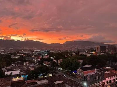 a city skyline with a sunset in the background at Exclusivo apartamento en Poblado con AC a 1 min Provenza in Medellín