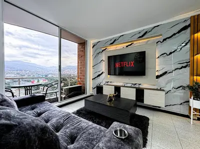 a living room with a couch and a tv at Exclusivo apartamento en Poblado con AC a 1 min Provenza in Medellín