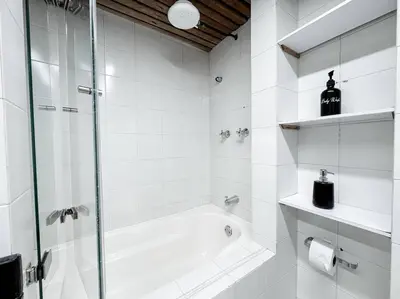 a white bathroom with a shower and a tub at Exclusivo apartamento en Poblado con AC a 1 min Provenza in Medellín