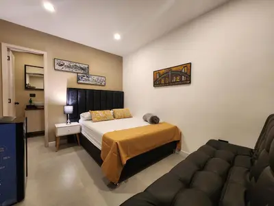 a hotel room with a bed and a couch at Loft 10, Suite Parque del Poblado 204 in Medellín