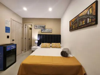 a bedroom with a large bed and a television at Loft 10, Suite Parque del Poblado 204 in Medellín