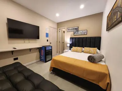 a bedroom with a large bed and a flat screen tv at Loft 10, Suite Parque del Poblado 204 in Medellín