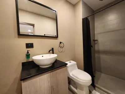 a bathroom with a sink and a toilet and a mirror at Loft 10, Suite Parque del Poblado 204 in Medellín