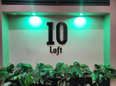 a clock on the side of a building with green lights at Loft 10, Suite Parque del Poblado 204 in Medellín