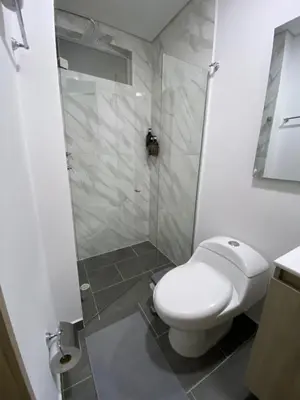 a bathroom with a white toilet and a shower at Hermoso y cómodo apartamento in Sabaneta
