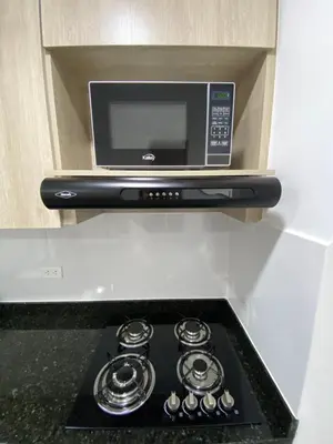 a microwave sitting on top of a stove in a kitchen at Hermoso y cómodo apartamento in Sabaneta