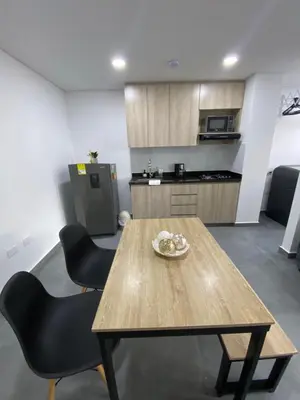 a table and chairs in a room with a kitchen at Hermoso y cómodo apartamento in Sabaneta