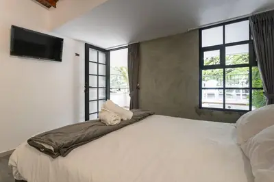 a bedroom with a large bed with a flat screen tv at ENCANTO - Provenza Private Villa with Heated Pool & Hot Tub Encanto NOWA in Medellín