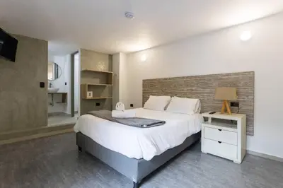 a bedroom with a large bed with a brick wall at ENCANTO - Provenza Private Villa with Heated Pool & Hot Tub Encanto NOWA in Medellín