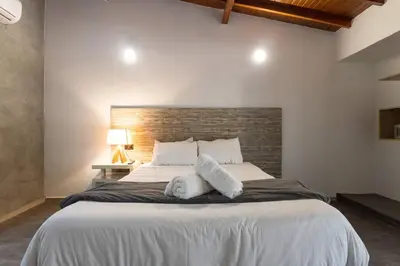 a bedroom with a large bed with a wooden headboard at ENCANTO - Provenza Private Villa with Heated Pool & Hot Tub Encanto NOWA in Medellín