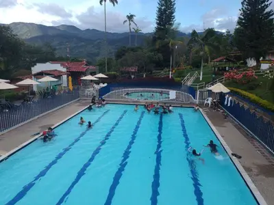 a group of people in a swimming pool at a resort at Yarumito Finca Hotel l Cabaña Pensamiento in Barbosa
