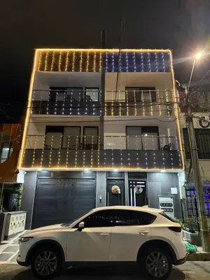 a white car parked in front of a building at night at Vive Medellin 401 in Medellín