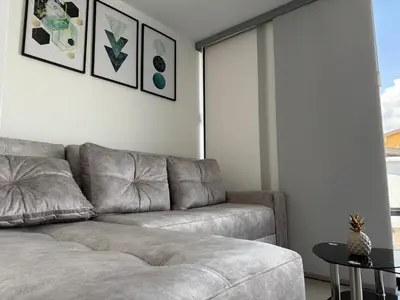 a living room with a gray couch and a table at Vive Medellin 401 in Medellín