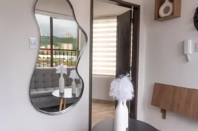 a mirror in a living room with a couch and a table at Apartamento en el Cable mejor zona en Manizales in Manizales