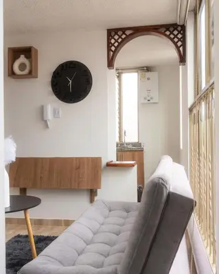 a living room with a couch and a clock on the wall at Apartamento en el Cable mejor zona en Manizales in Manizales