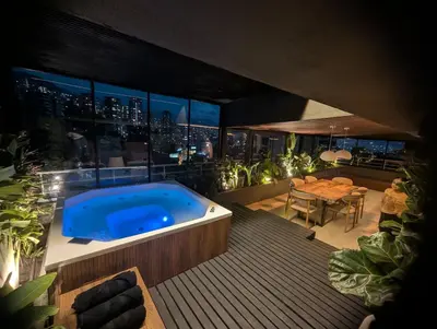 a hot tub on a deck with a view of the city at Apartamento - penthouse cyan in Medellín