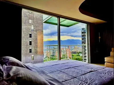 a bedroom with a large window with a large bed at Apartamento - penthouse cyan in Medellín