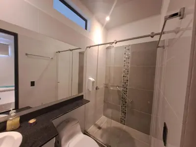 a bathroom with a toilet and a glass shower at Hotel Luna Verde in Doradal