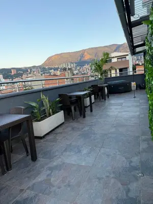 a balcony with tables and chairs on a building at Vive Medellin 302 in Medellín