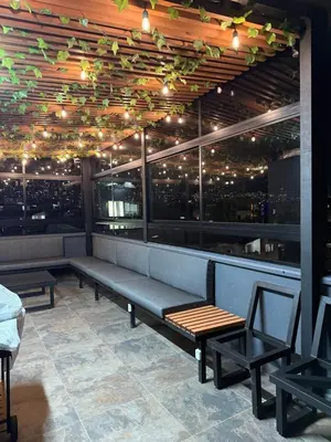a restaurant with benches and a bar with lights at Vive Medellin 302 in Medellín