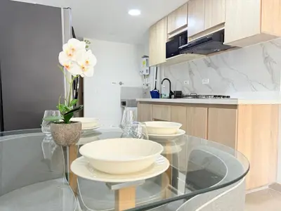 a kitchen with a glass table with bowls on it at Vive Medellin 302 in Medellín