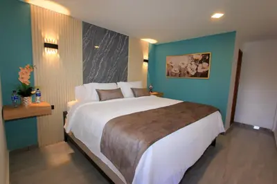 a bedroom with a large bed with a blue wall at Hotel y Termales Castillo Del Lago Guatape in Horizonte