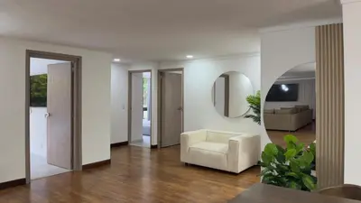 a living room with a chair and a mirror at 4BR 240 m² Fully Refurbished El Tesoro in Medellín