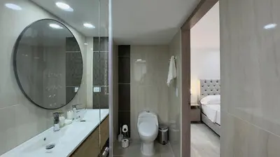 a bathroom with a toilet and a sink and a mirror at 4BR 240 m² Fully Refurbished El Tesoro in Medellín