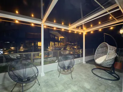 two chairs sitting on a balcony at night at 4BR 240 m² Fully Refurbished El Tesoro in Medellín