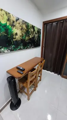 a wooden table and chair in a room with a painting at El Amañadero Paisa in Envigado