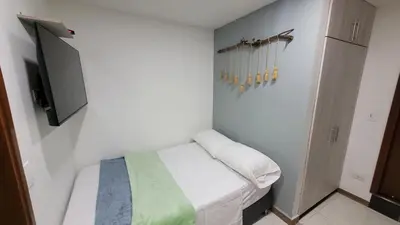 a small bedroom with a bed and a tv at El Amañadero Paisa in Envigado