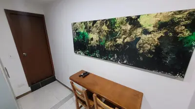 a painting hanging on a wall next to a wooden bench at El Amañadero Paisa in Envigado
