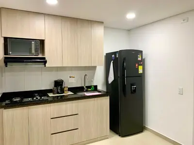 a kitchen with a black refrigerator and a microwave at Piso27 PROMO! LUJOSO APARTAMENTO, PARKING Y ZONAS HUMEDAS in Sabaneta