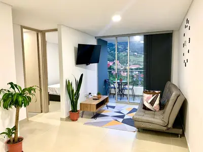 a living room with a chair and a table at Piso27 PROMO! LUJOSO APARTAMENTO, PARKING Y ZONAS HUMEDAS in Sabaneta