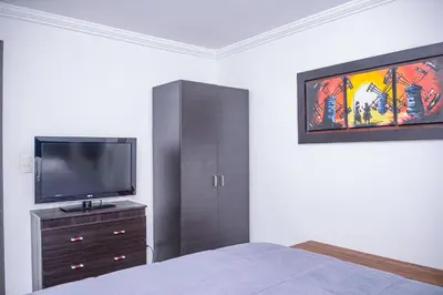 a bedroom with a bed and a tv on a wall at Apartment Carrera 301 in Medellín