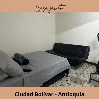 a bedroom with a bed and a leather couch at Casa Jacinto in Ciudad Bolívar