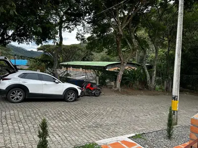 a white car parked next to a motor scooter at Casa Jacinto in Ciudad Bolívar