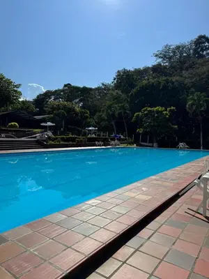 a swimming pool with a chair next to it at Acogedora cabaña en la Pintada in La Pintada