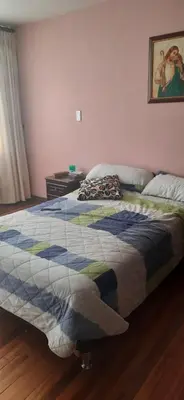 a bedroom with a bed with a quilt on it at Casa para ferias manizales in Manizales