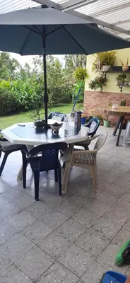 a table and a bench under an umbrella at Casa para ferias manizales in Manizales