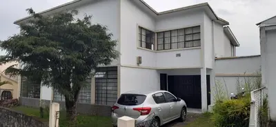 a white house with a car parked in front of it at Casa para ferias manizales in Manizales