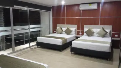 a hotel room with two beds and windows at Hotel Med 33 in Medellín