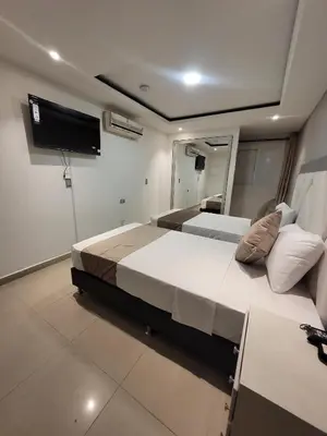a bedroom with a large bed and a flat screen tv at Hotel Med 33 in Medellín