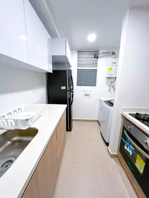 a kitchen with a sink and a black refrigerator at Maravillosas vistas, excelente ubicación in Manizales