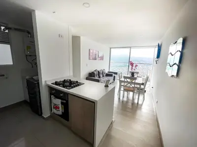 a kitchen and living room with a stove and a table at Maravillosas vistas, excelente ubicación in Manizales